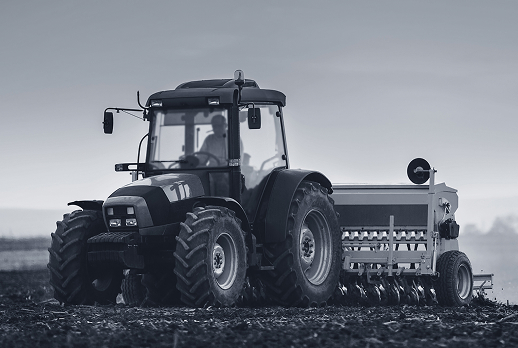 Tractor operating in a field with agricultural equipment attached