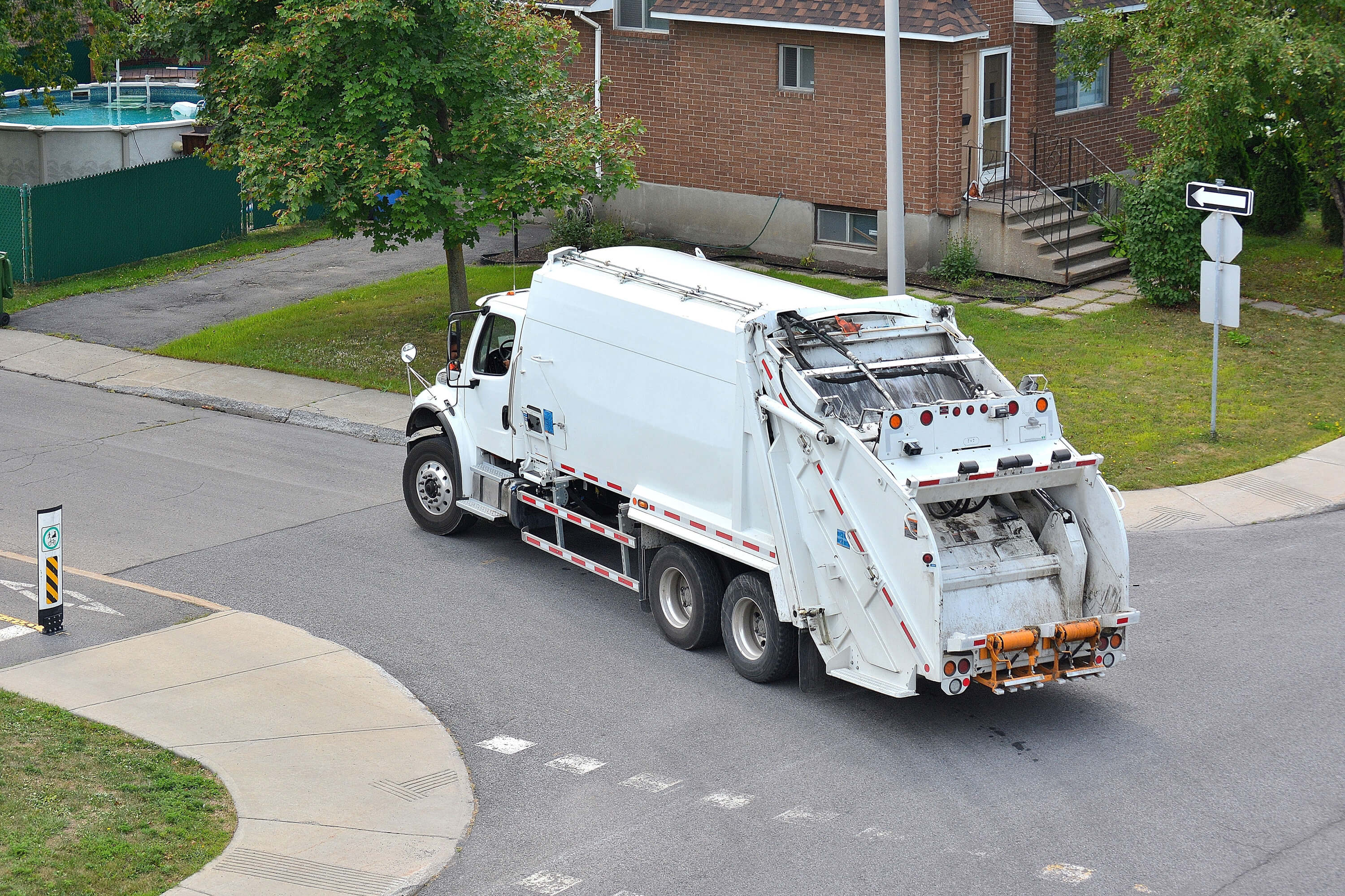 white garbage truck turning